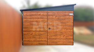 3×6m große Premium-Mobilgarage mit nach links geneigtem Pultdach, Garagentor und Seitentür in Goldeiche, anthrazitgrauen Wänden und Dach, einem Fenster und Verkleidungen