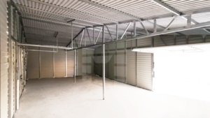 14,35x6m-es mobilgarázs nyeregtetővel (10x6m-es zárt garázs, bal oldalán 1,35x6m-es, jobb oldalán 3x6m-es oldaltető), 2db billenőkapuval, 2db ajtóval, horganyzott zártszelvényes vázszerkezettel, vízszintes fehér lemezborítással